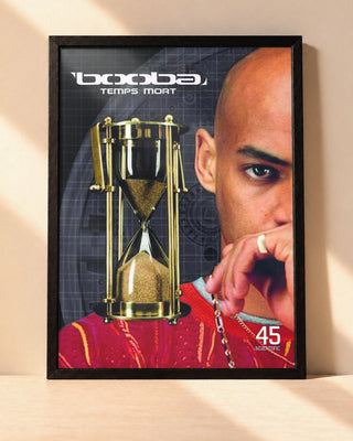 Poster Booba – Temps Mort encadré dans un cadre noir, posé contre un mur clair