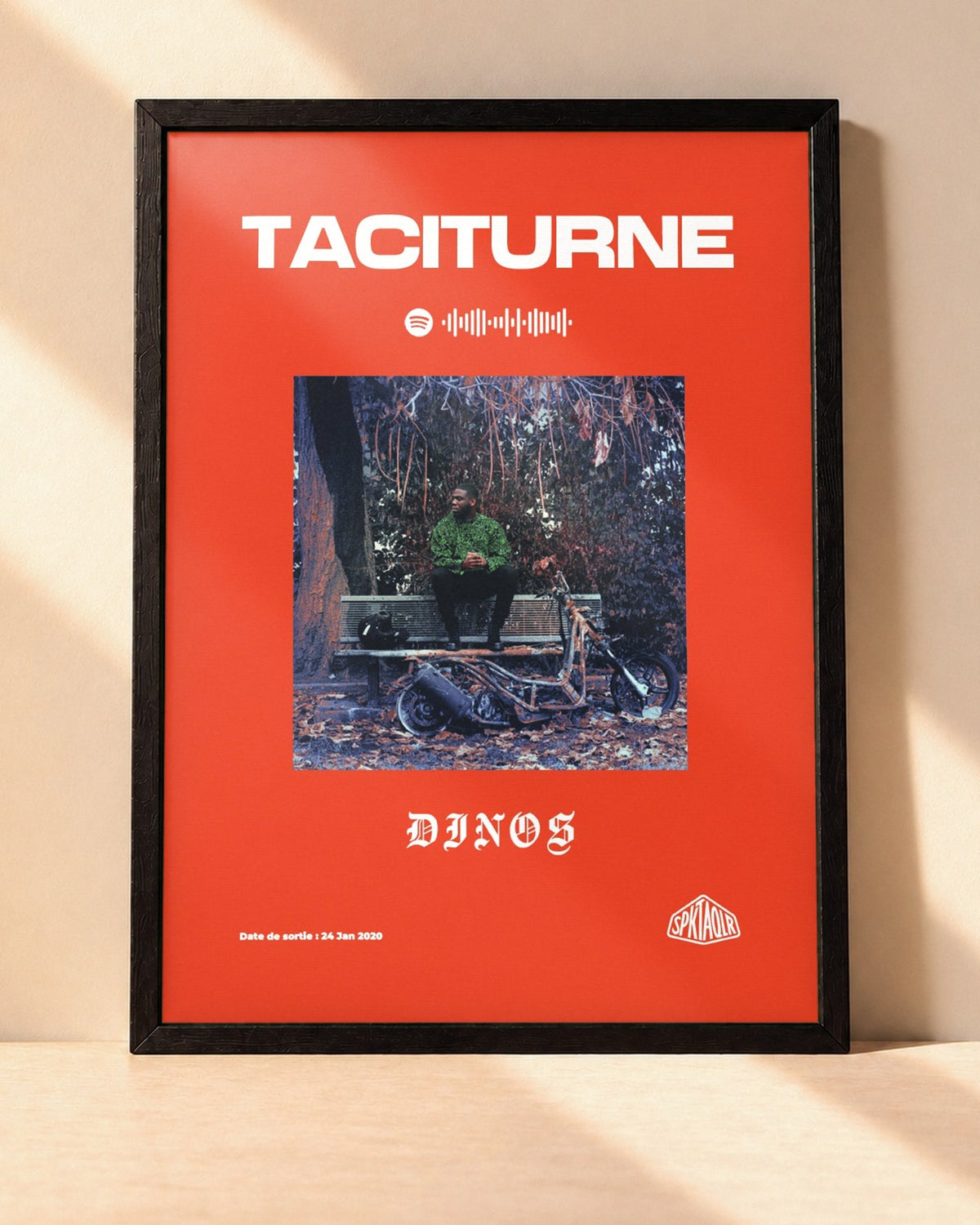 Poster Dinos – Taciturne encadré dans un cadre noir, posé contre un mur clair