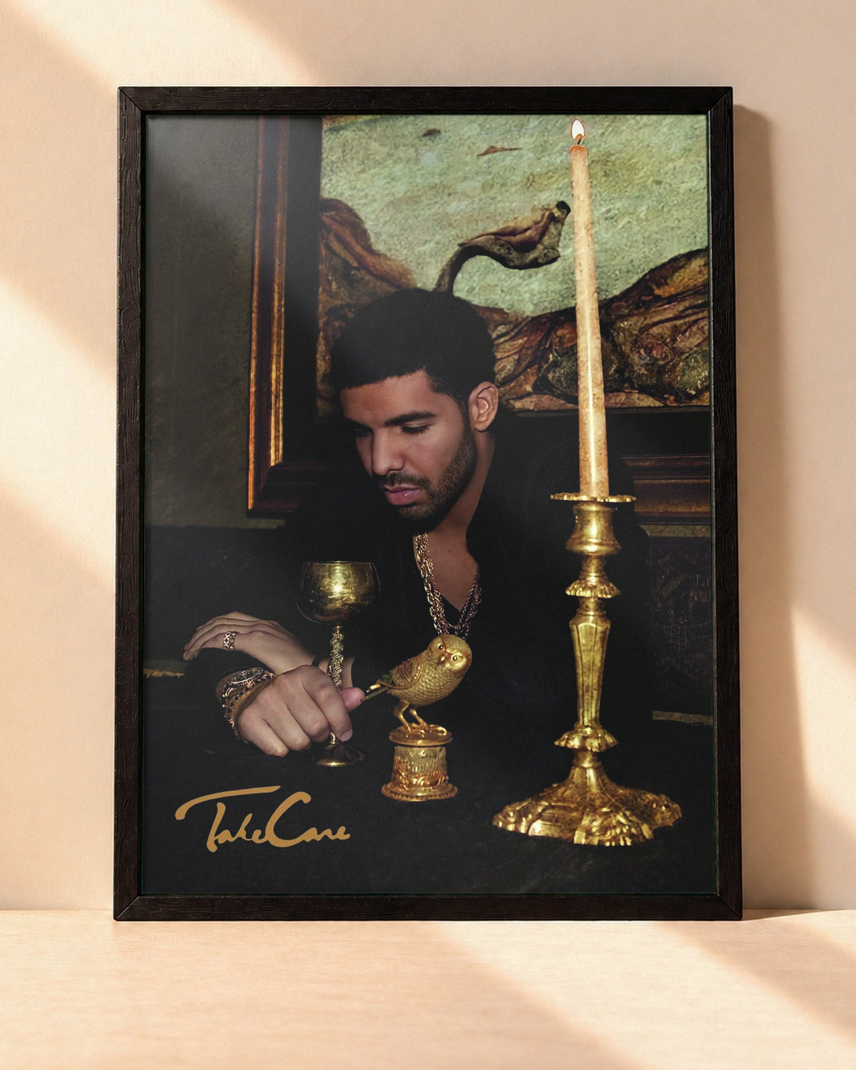 Poster Drake – Take Care encadré dans un cadre noir, posé contre un mur clair