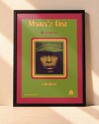 Poster Erykah Badu – Mama's Gun encadré dans un cadre noir, posé contre un mur clair