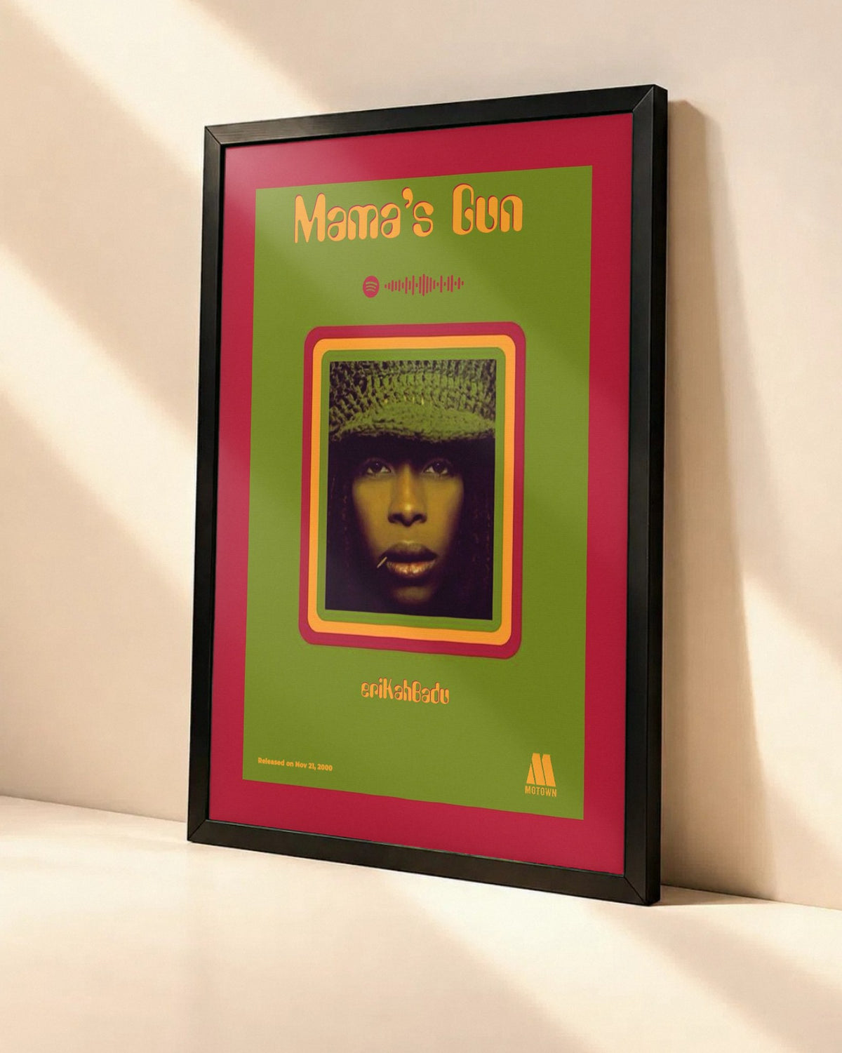 Poster Erykah Badu – Mama's Gun dans un cadre noir, vue en angle