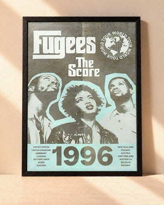 Poster Fugees – 1996 encadré dans un cadre noir, posé contre un mur clair