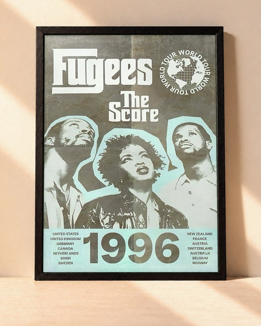 Poster Fugees – 1996 encadré dans un cadre noir, posé contre un mur clair