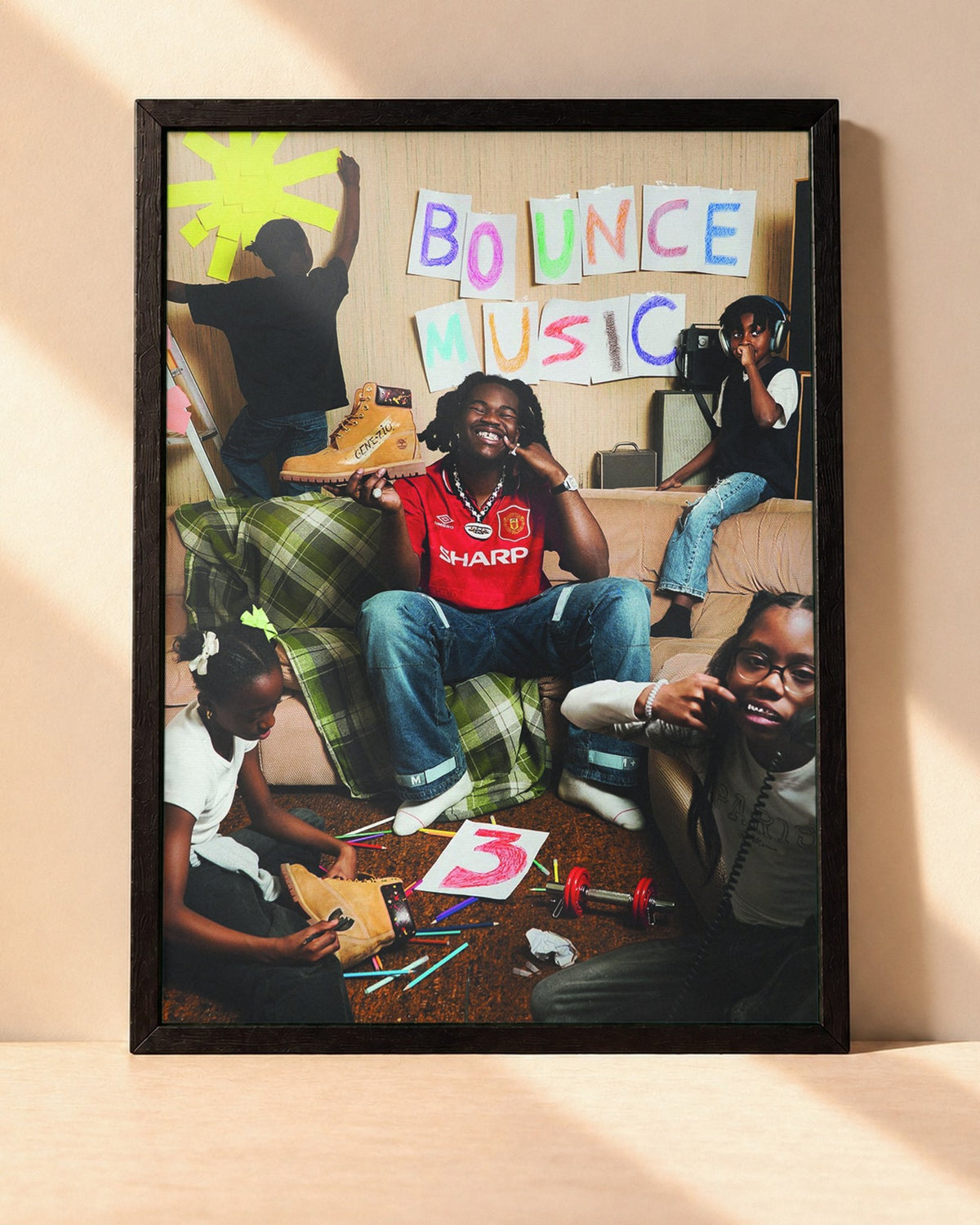 Poster Genezio – Bouce Musique Vol3 encadré dans un cadre noir, posé contre un mur clair