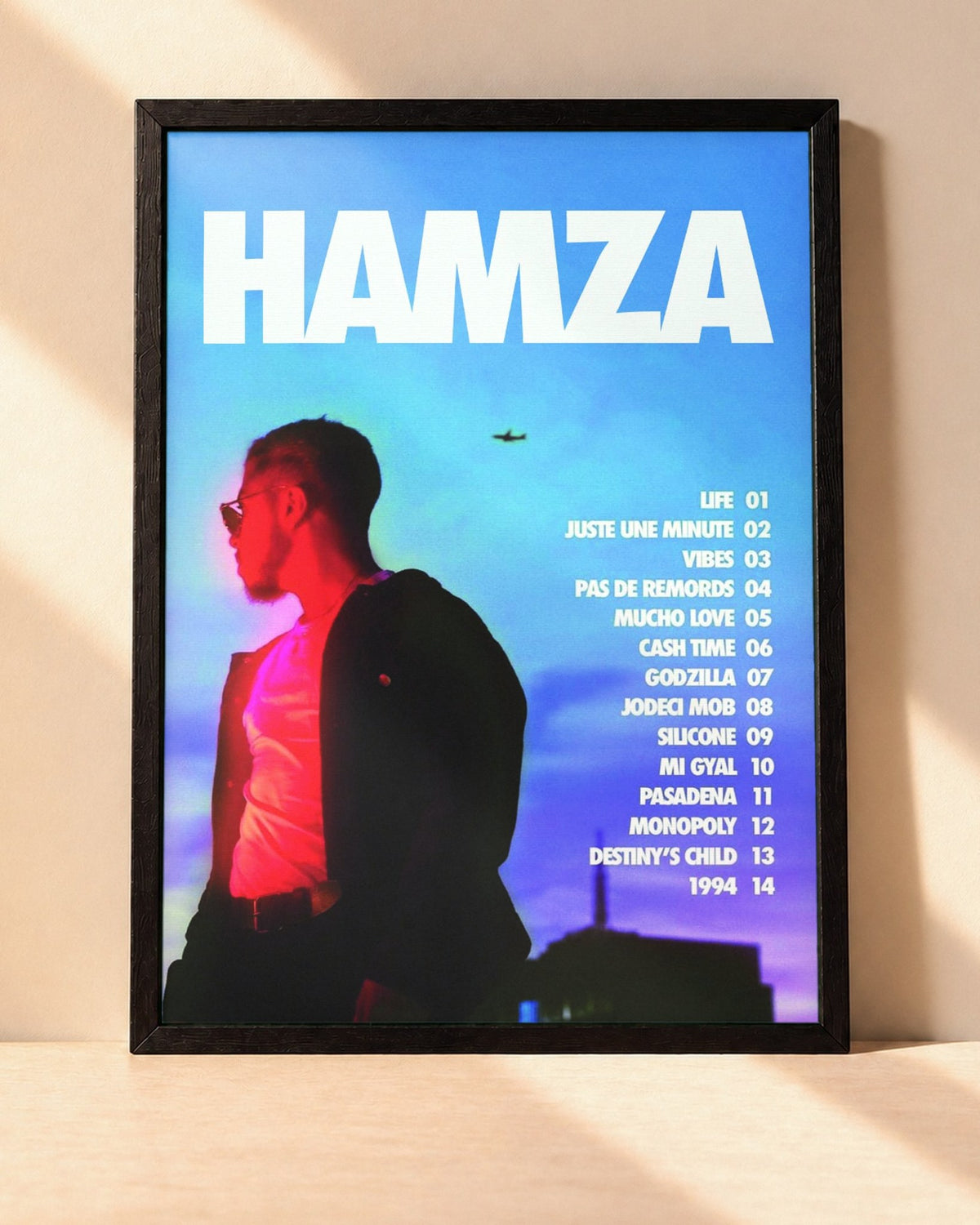 Poster Hamza – 1994 encadré dans un cadre noir, posé contre un mur clair