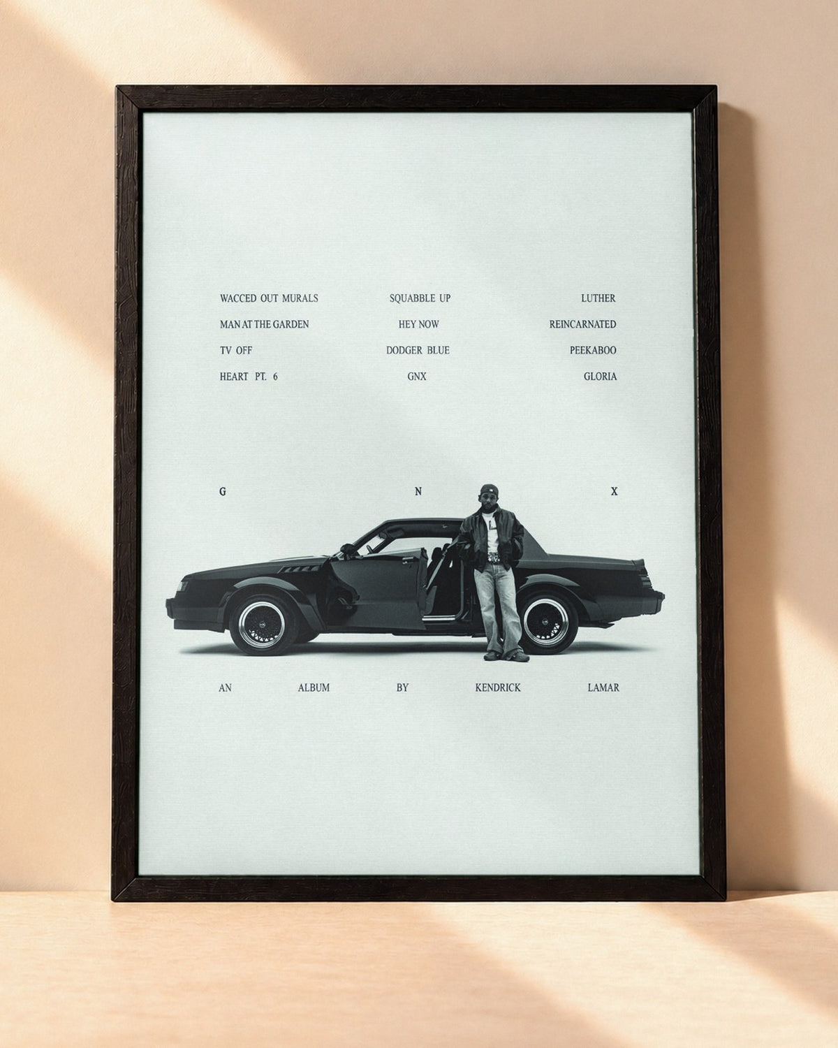 Poster Kendrick Lamar – GNX encadré dans un cadre noir, posé contre un mur clair
