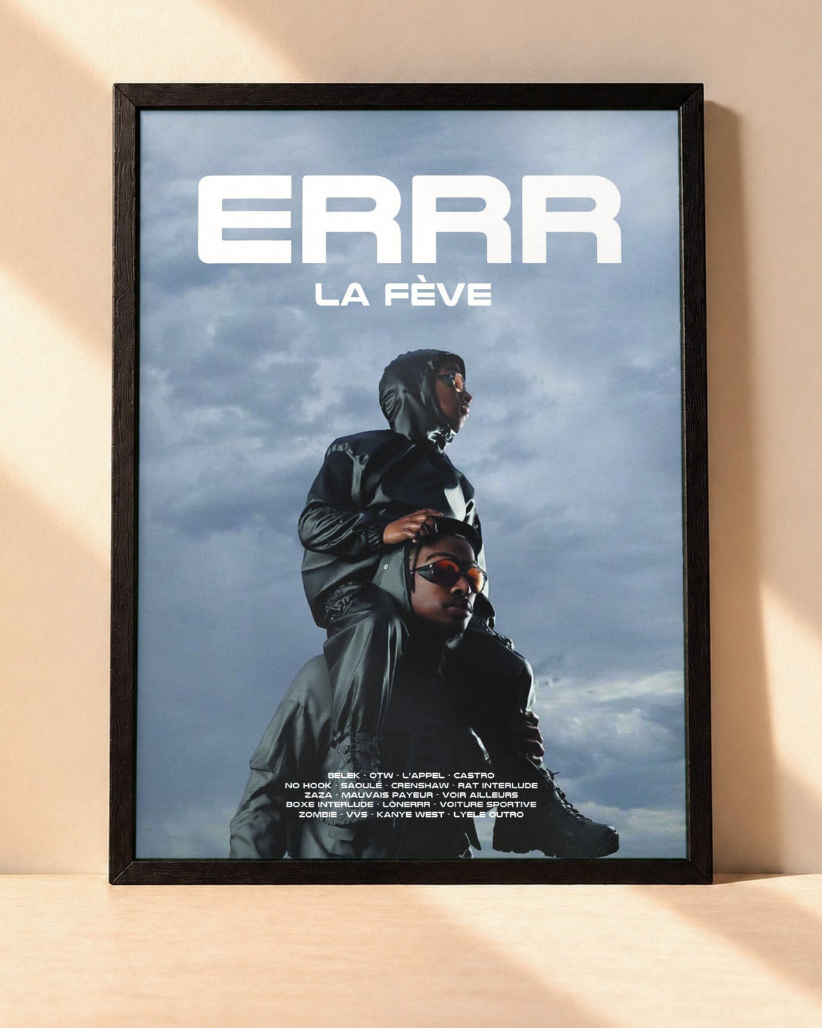 Poster La Fève – Errr encadré dans un cadre noir, posé contre un mur clair