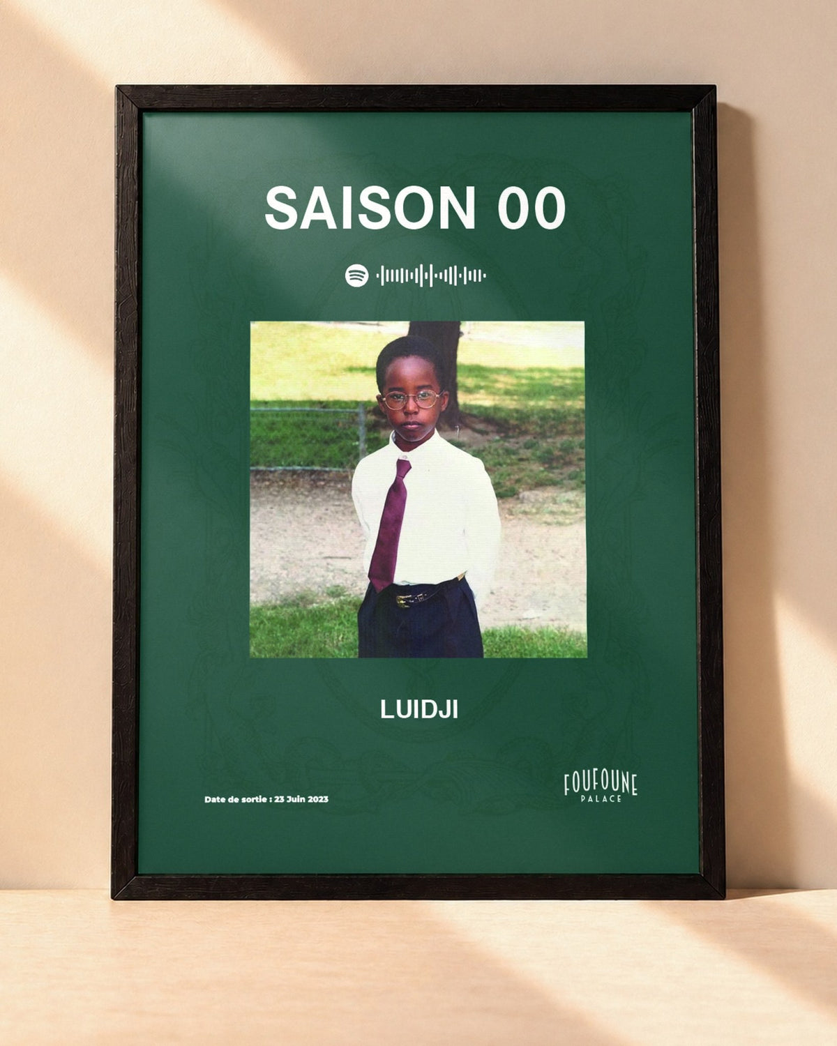 Poster Luidji – Saison 00 encadré dans un cadre noir, posé contre un mur clair
