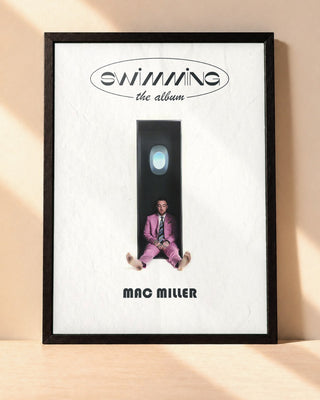 Poster Mac Miller – Swimming encadré dans un cadre noir, posé contre un mur clair