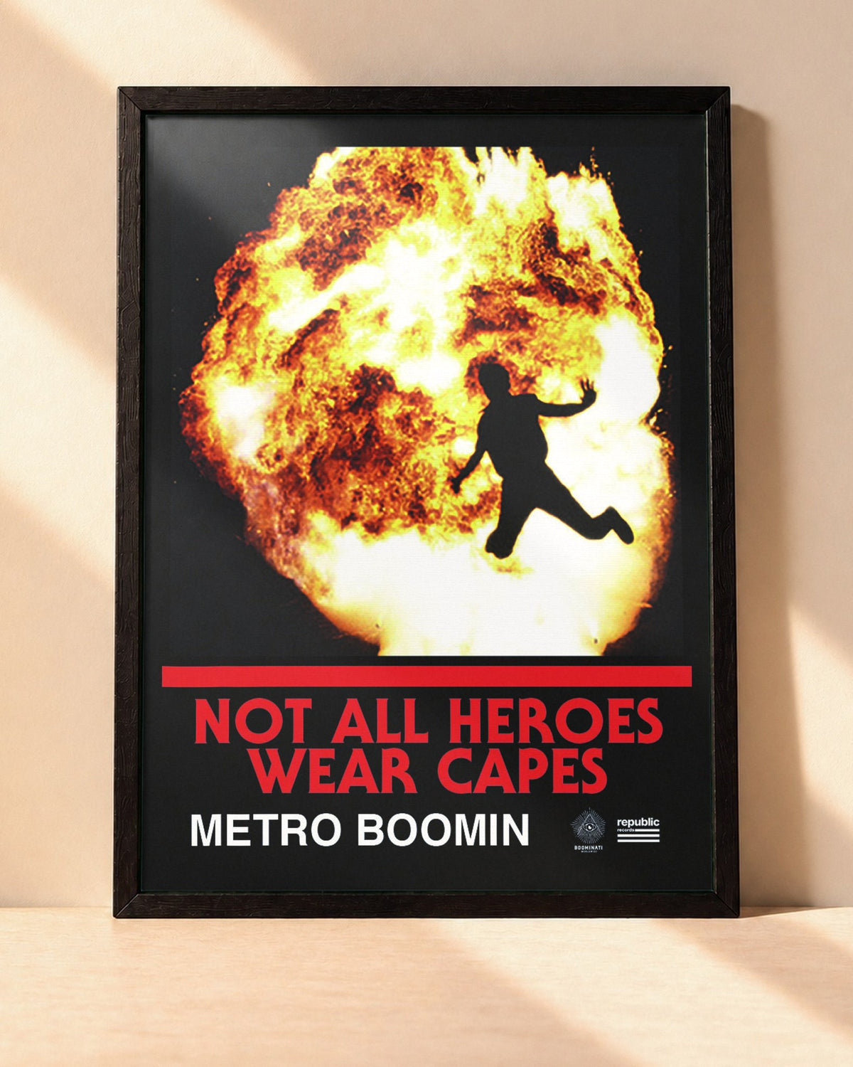 Poster Metro Boomin – Not All Heroes Wear Capes encadré dans un cadre noir, posé contre un mur clair