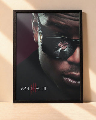 Poster Ninho – M.I.L.S III encadré dans un cadre noir, posé contre un mur clair