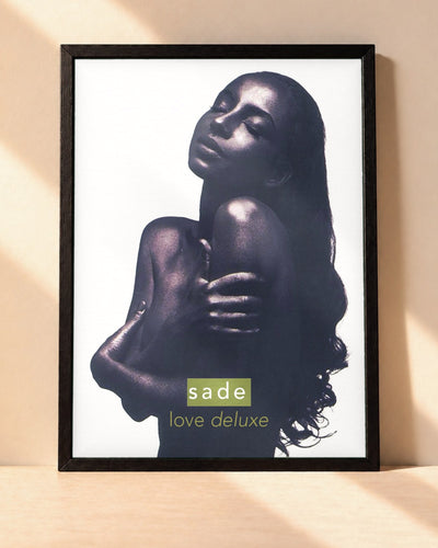 Poster Sade – Love Deluxe encadré dans un cadre noir, posé contre un mur clair