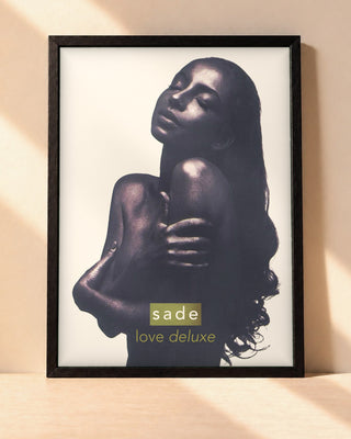 Poster Sade – Love Deluxe encadré dans un cadre noir, posé contre un mur clair