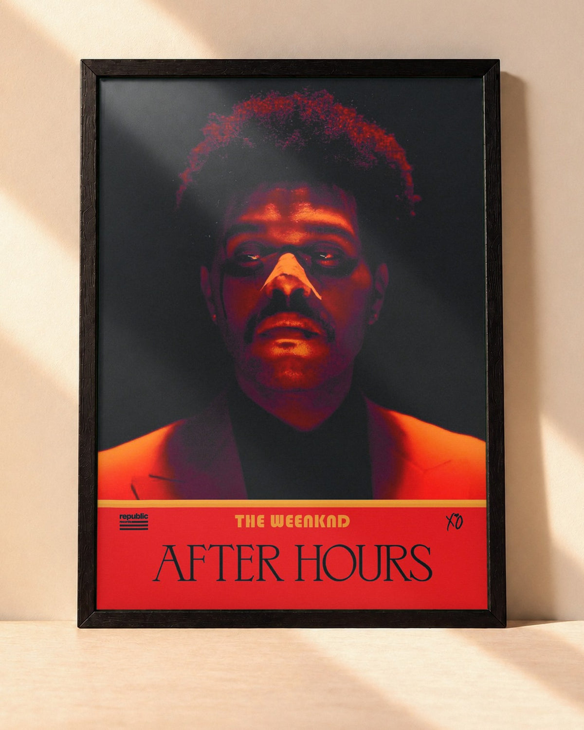 Poster The Weeknd – After Hours encadré dans un cadre noir, posé contre un mur clair