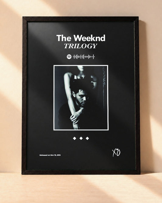 Poster The Weeknd – Trilogy encadré dans un cadre noir, posé contre un mur clair