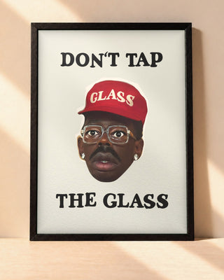 Poster Tyler, The Creator – Don't Tap The Glass encadré dans un cadre noir, posé contre un mur clair